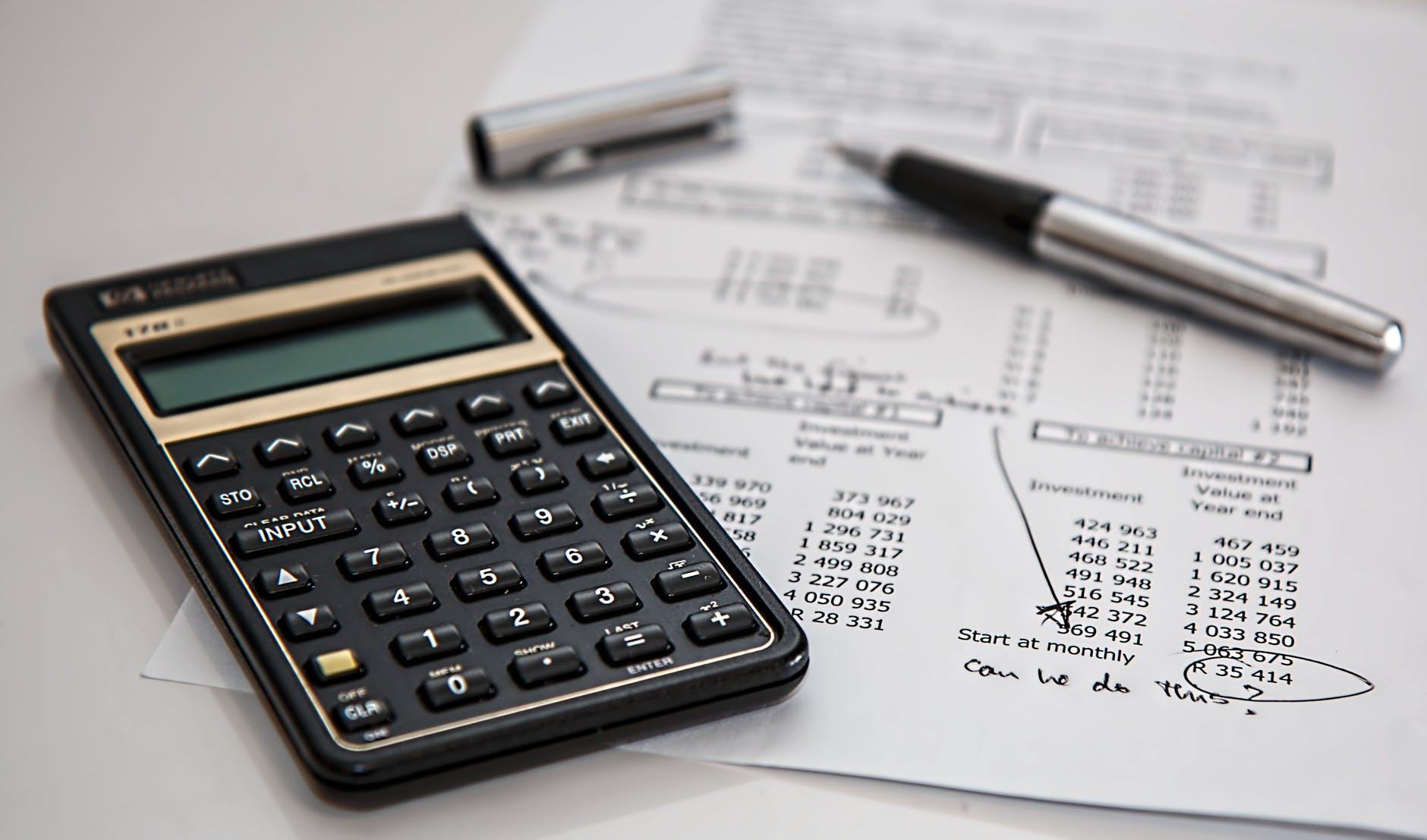 black calculator near ballpoint pen on white printed paper - how to make money from debt