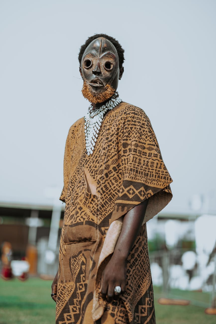 unrecognizable black man in mask on lawn